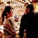 Two couples talk while waiting for drinks at a brightly lit bar